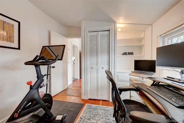 a view of a workspace with furniture and a window