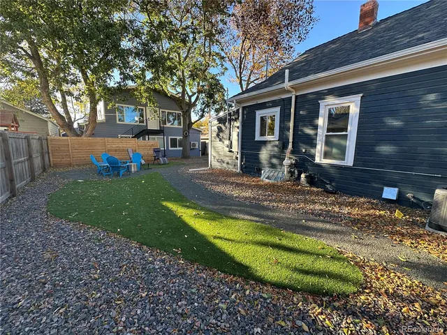 a view of a house with backyard and sitting area