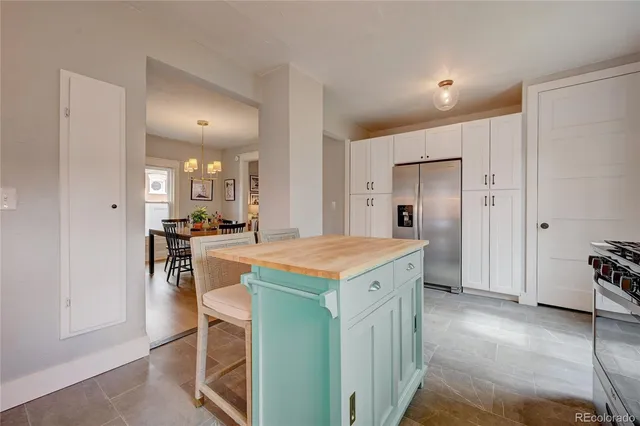 a kitchen with a stove a refrigerator a sink and a dining table