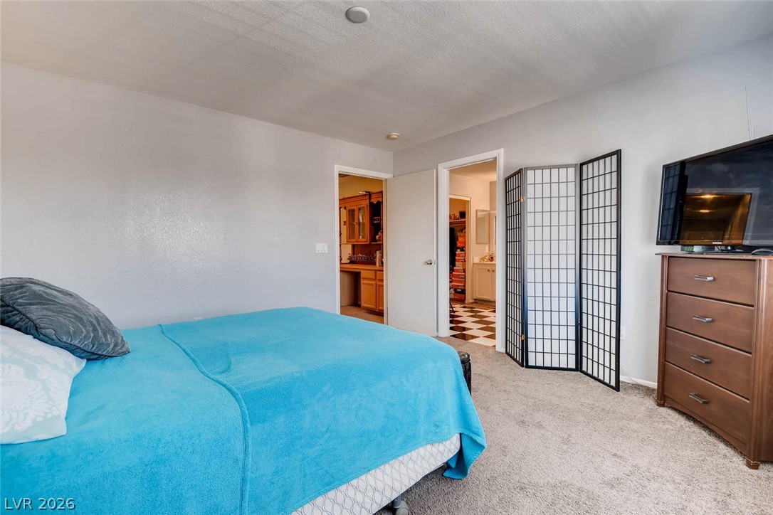 10451 Processor Court Las Vegas, NV 89129 - Photo 17 of 28 Comfortable bedroom retreat with plush carpet and easy access to a secondary space.