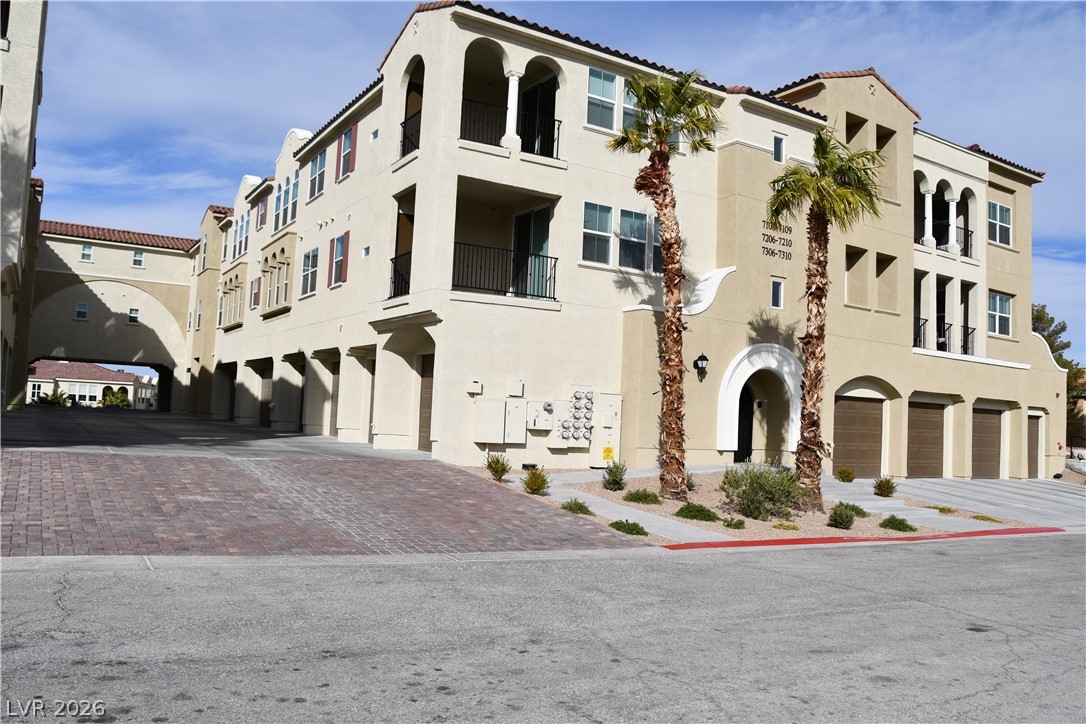 2555 Hampton Road, Unit 7109 Henderson, NV 89052 - Photo 2 of 34 Mediterranean-inspired multi-story residence with attached garages and a decorative arched walkway.