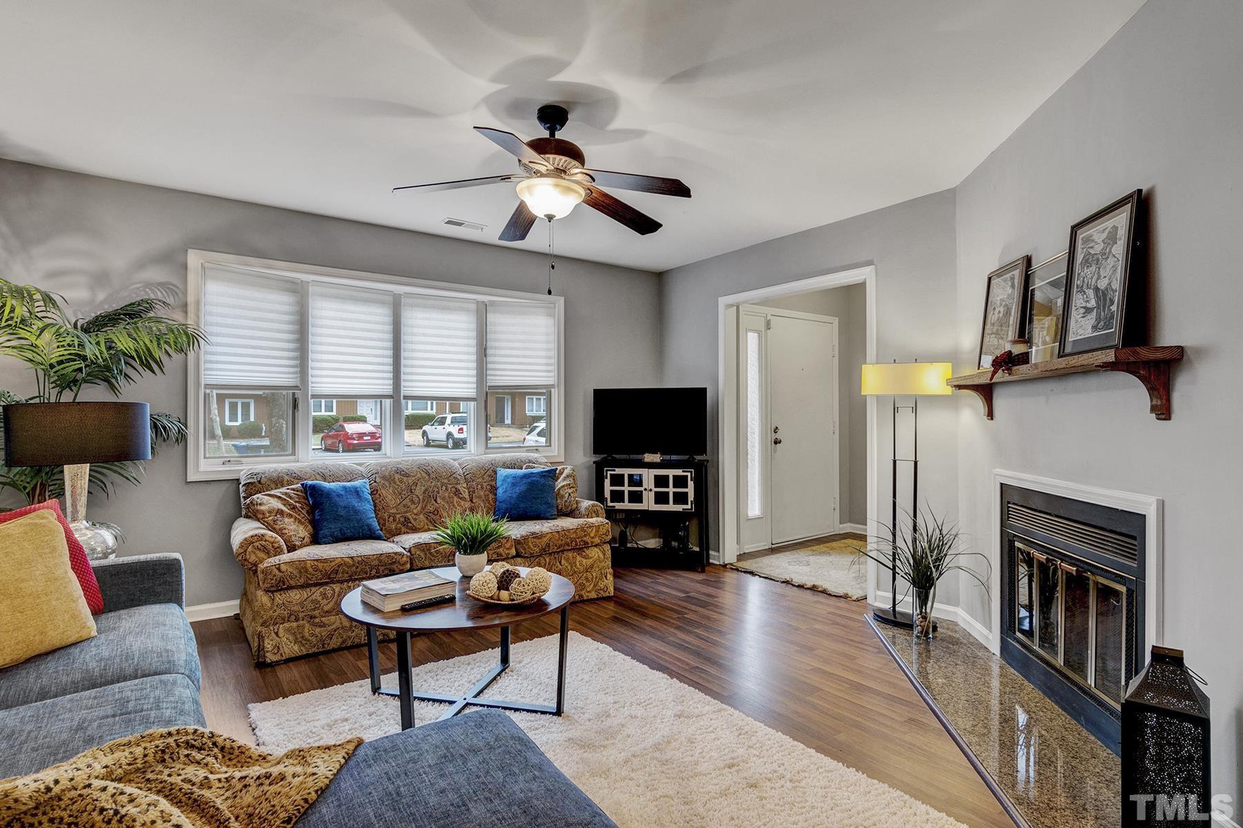 27 Sunflower Court Durham, NC 27713 - Photo 3 of 18 a living room with furniture a fireplace and a flat screen tv