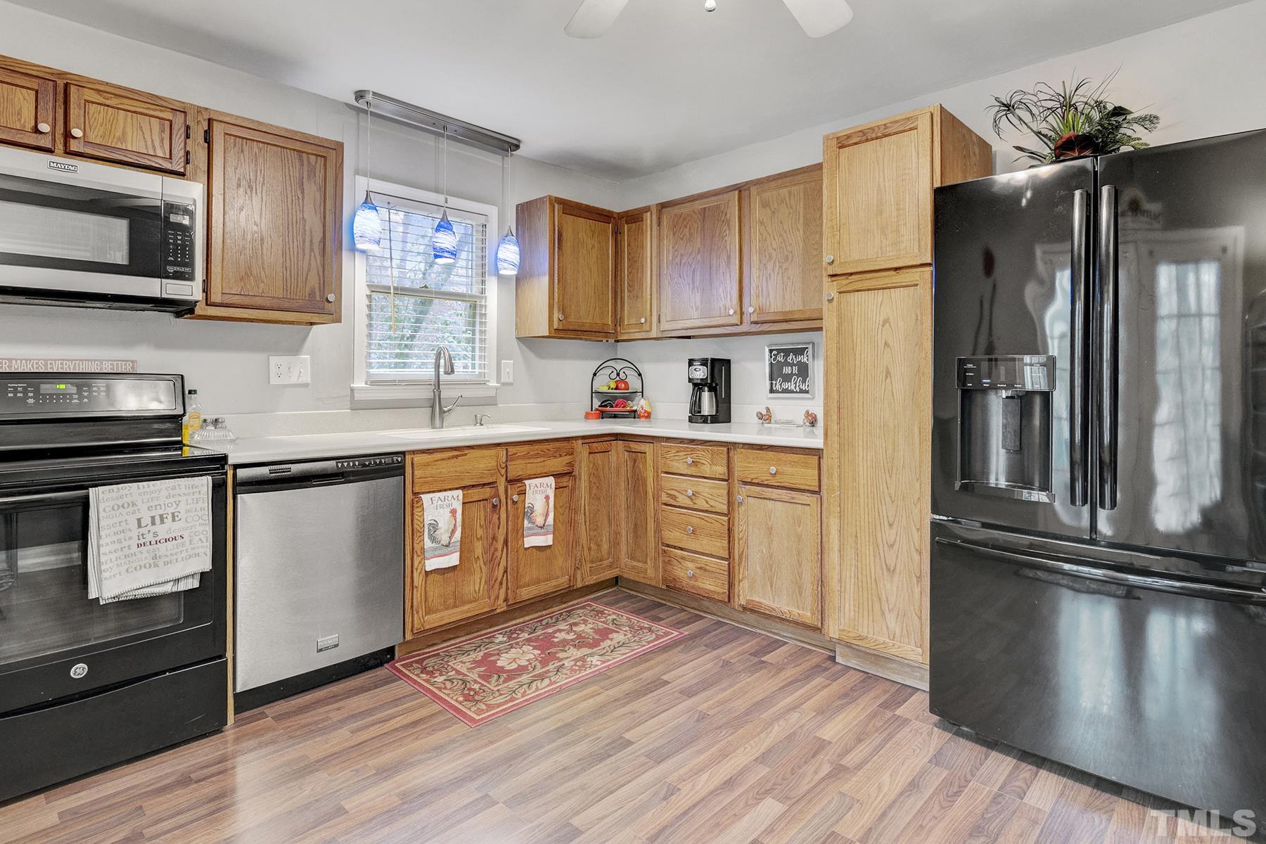 27 Sunflower Court Durham, NC 27713 - Photo 8 of 18 a kitchen with stainless steel appliances granite countertop a refrigerator a sink dishwasher a stove with wooden floor and cabinets