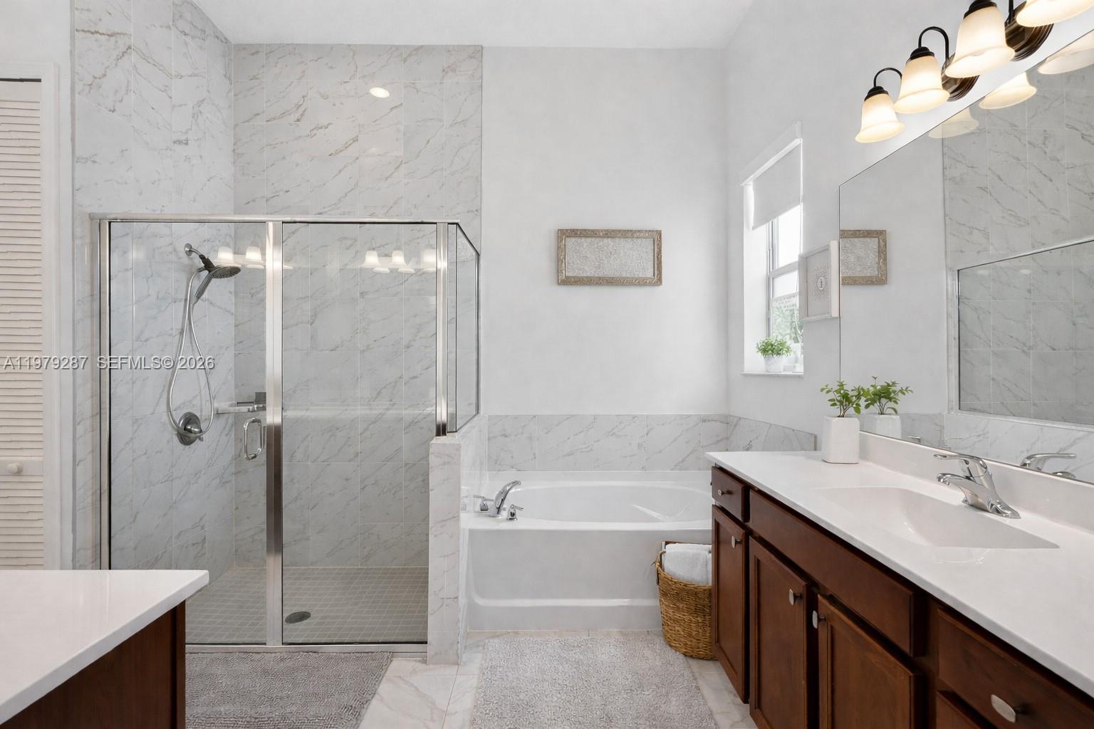 14929 Southwest 176th Terrace Miami, FL 33187 - Photo 15 of 40 a bathroom with a tub sink shower and two mirror