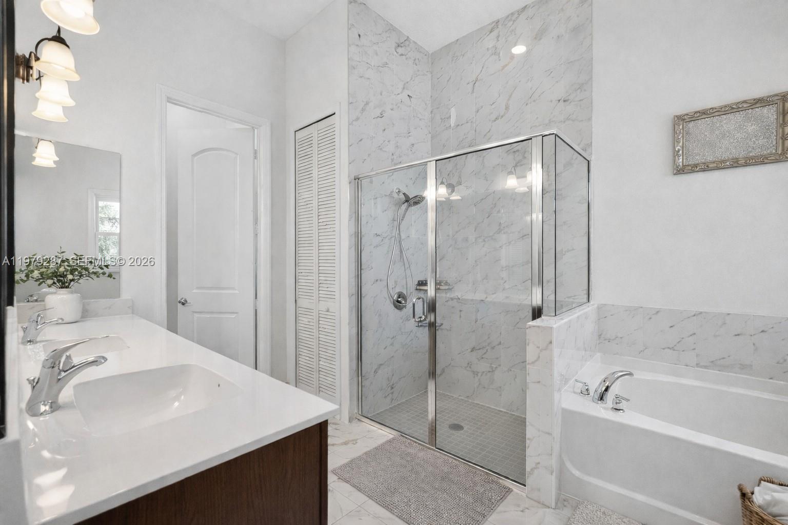 14929 Southwest 176th Terrace Miami, FL 33187 - Photo 16 of 40 a bathroom with a bath tub sink mirror and shower