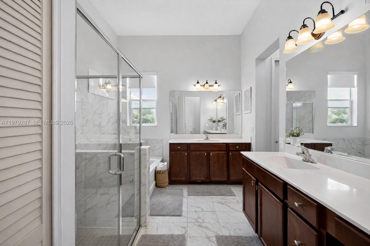 14929 Southwest 176th Terrace Miami, FL 33187 - Photo 17 of 40 a bathroom with a double vanity sink mirror and shower