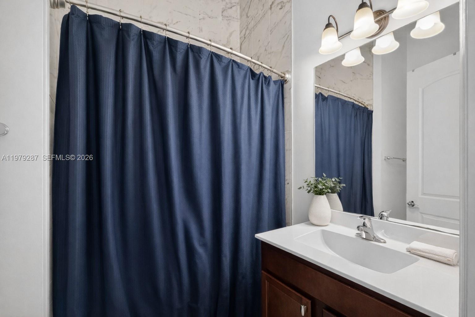 14929 Southwest 176th Terrace Miami, FL 33187 - Photo 21 of 40 a bathroom with a sink vanity and a mirror