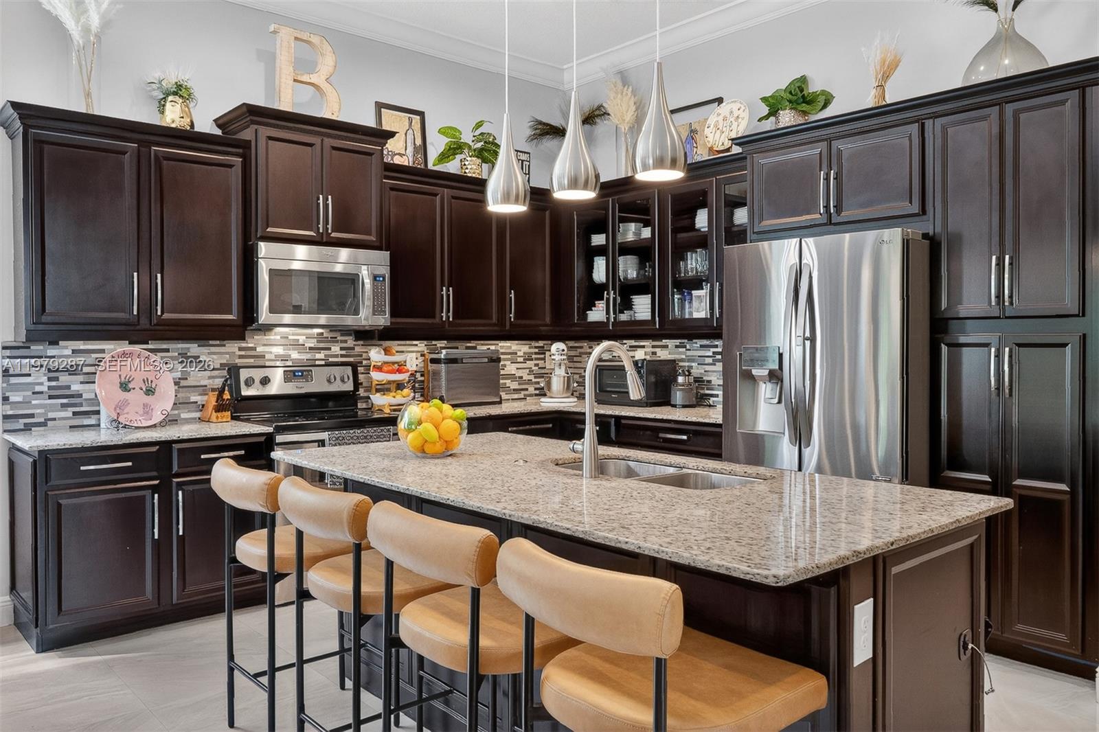 14929 Southwest 176th Terrace Miami, FL 33187 - Photo 40 of 40 a kitchen with granite countertop a table chairs stove and refrigerator