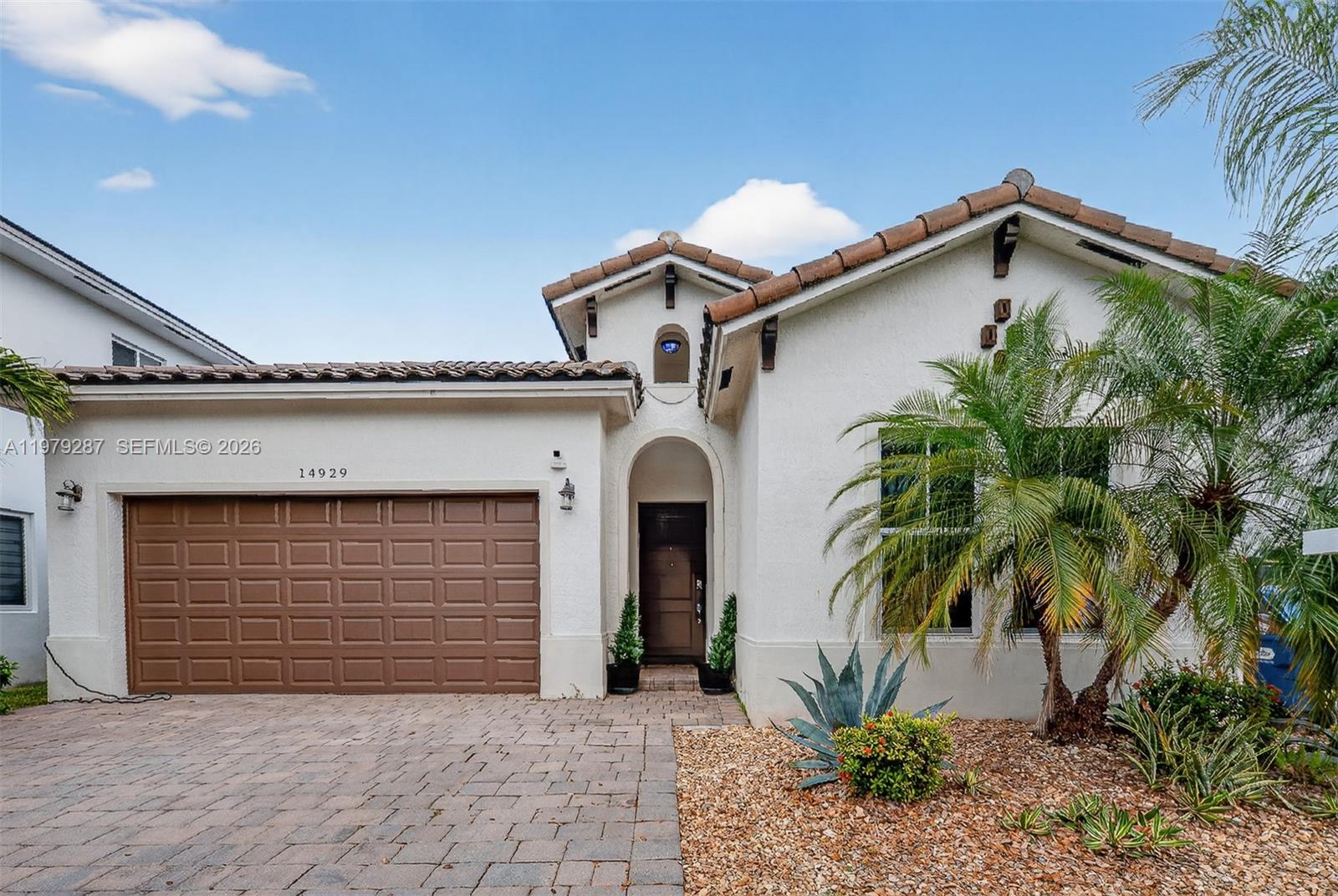 14929 Southwest 176th Terrace Miami, FL 33187 - Photo 4 of 40 a front view of a house with garden