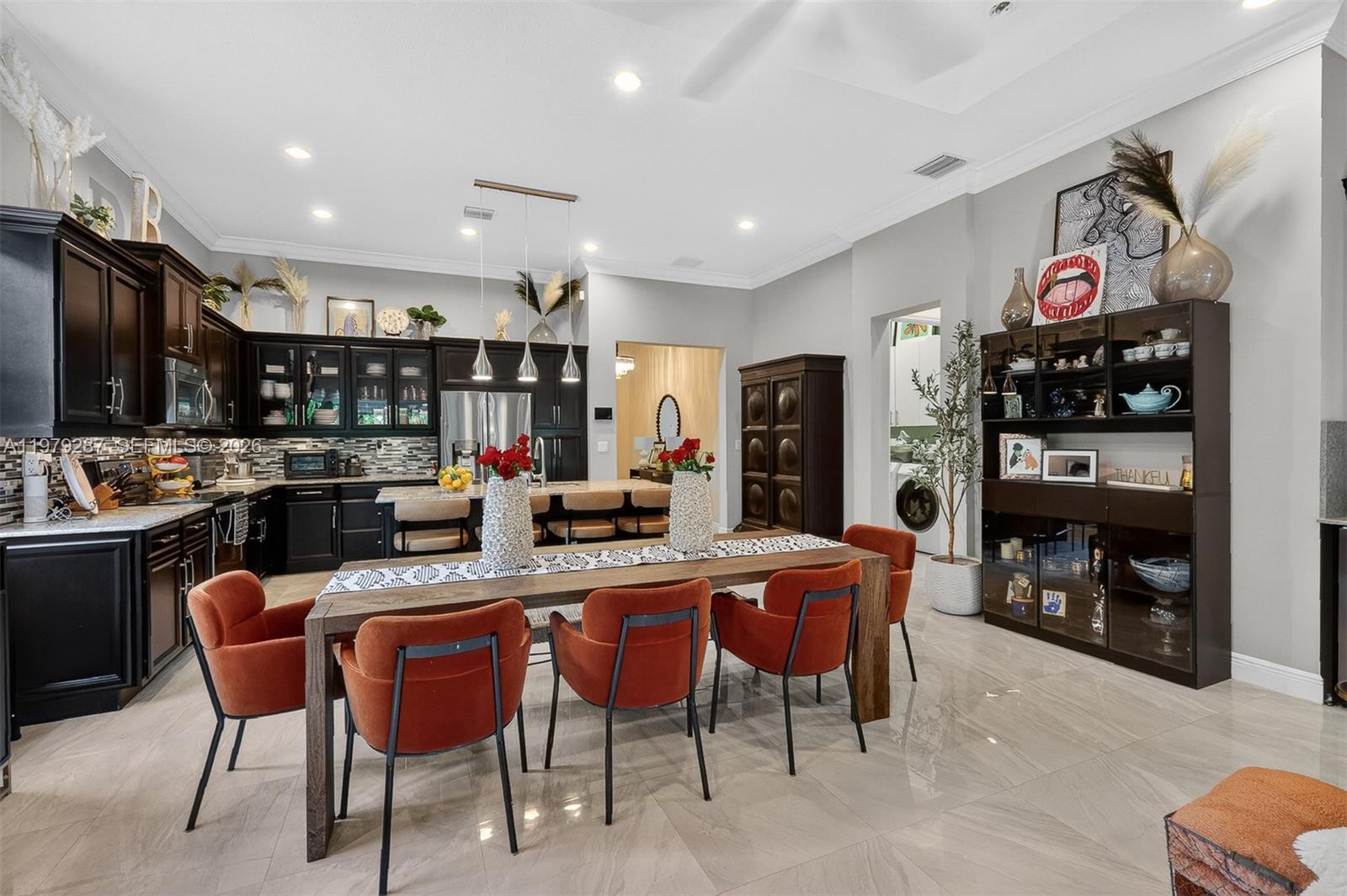 14929 Southwest 176th Terrace Miami, FL 33187 - Photo 7 of 40 a kitchen with stainless steel appliances kitchen island granite countertop a refrigerator a stove a sink and a dining table with garden view