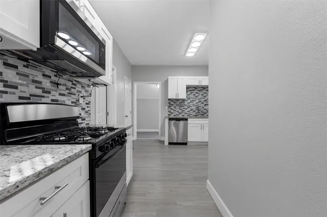 a kitchen with stainless steel appliances a stove and a microwave