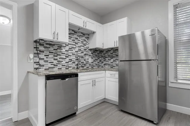 a kitchen with stainless steel appliances granite countertop a refrigerator sink and cabinets
