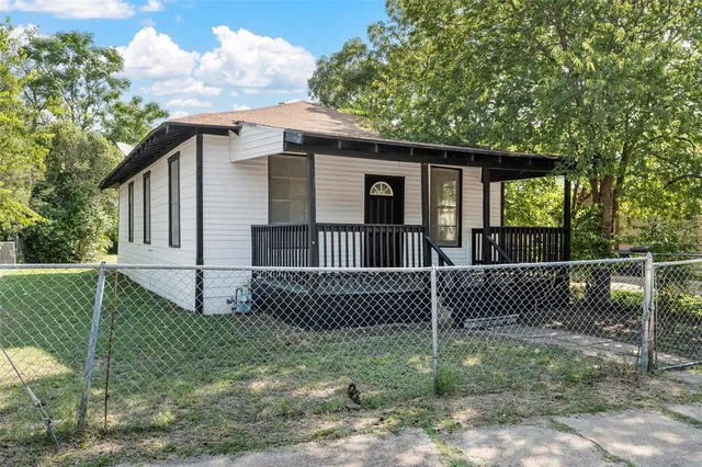 a view of a house with a fence and a yard