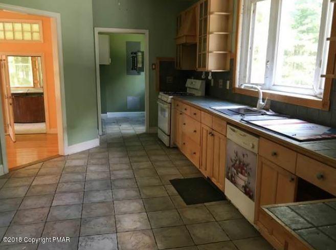 1090 Milford Road Dingmans Ferry, PA 18328 - Photo 5 of 13 a kitchen with a sink a counter and cabinets