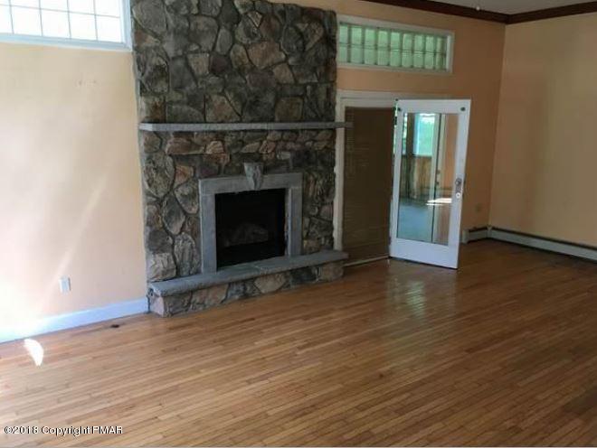 1090 Milford Road Dingmans Ferry, PA 18328 - Photo 7 of 13 a view of a livingroom with wooden floor a fireplace and window