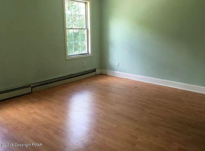 1090 Milford Road Dingmans Ferry, PA 18328 - Photo 9 of 13 an empty room with wooden floor and windows