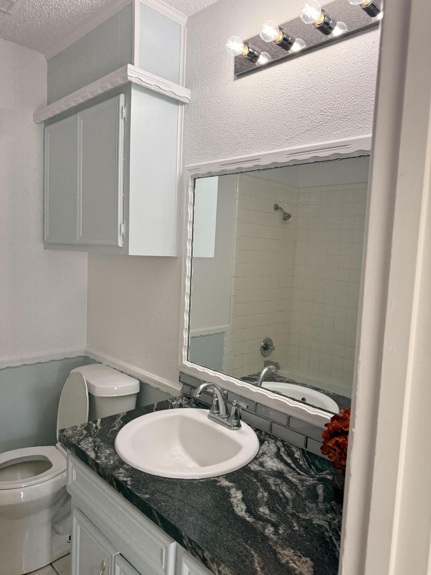 5510 Amherst Street Lubbock, TX 79416 - Photo 14 of 21 a bathroom with a granite countertop sink and a mirror
