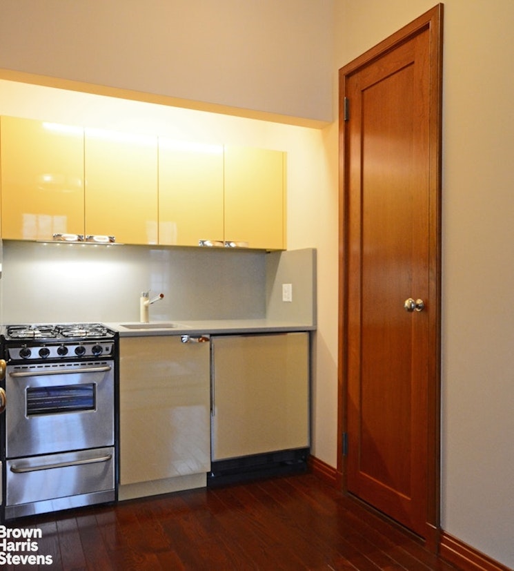 428 West 44th Street Manhattan, NY 10036 - Photo 11 of 17 a kitchen with a refrigerator and a stove top oven
