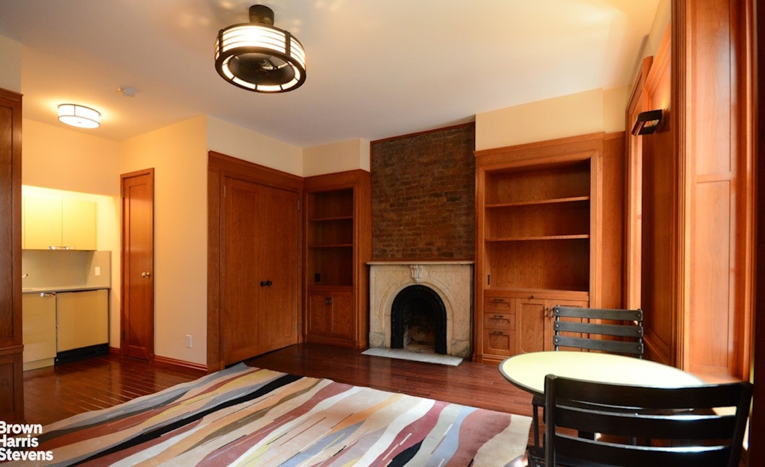 428 West 44th Street Manhattan, NY 10036 - Photo 13 of 17 a living room with furniture a fireplace and a table
