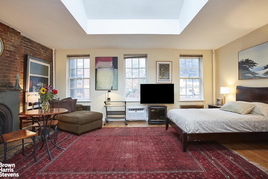 428 West 44th Street Manhattan, NY 10036 - Photo 16 of 17 a bedroom with a bed and a couch