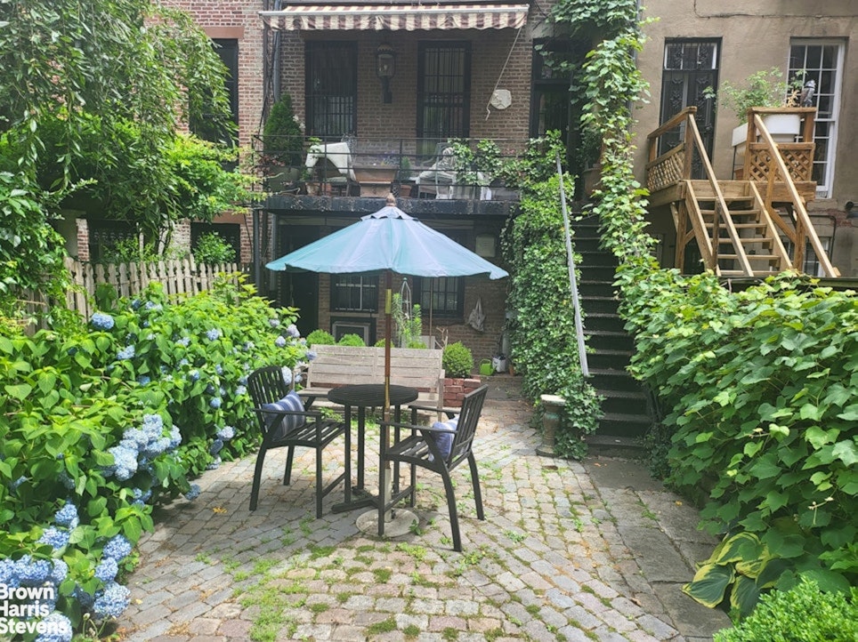 428 West 44th Street Manhattan, NY 10036 - Photo 10 of 17 a patio with a table and chairs under an umbrella