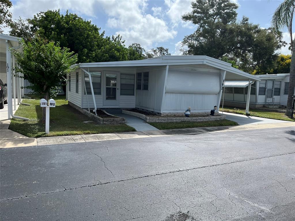 1040 Main Street, Unit 192 Dunedin, FL 34698 - Photo 1 of 15 a house with trees in the background