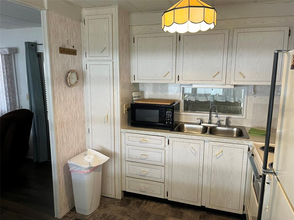 1040 Main Street, Unit 192 Dunedin, FL 34698 - Photo 13 of 15 a kitchen with a sink a refrigerator and cabinets