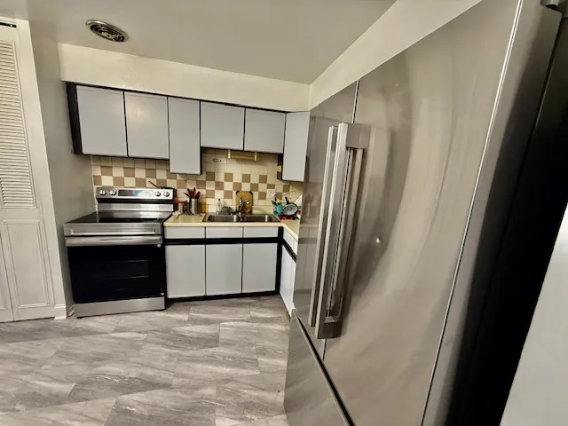 a kitchen with stainless steel appliances a refrigerator and a sink
