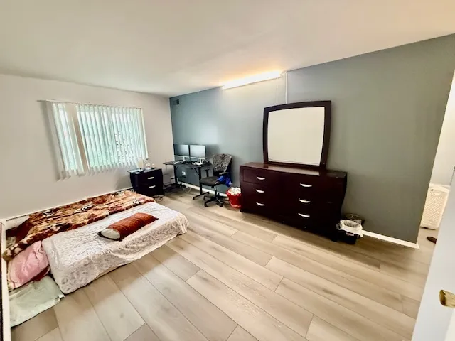 a bedroom with a bed and dresser with mirror