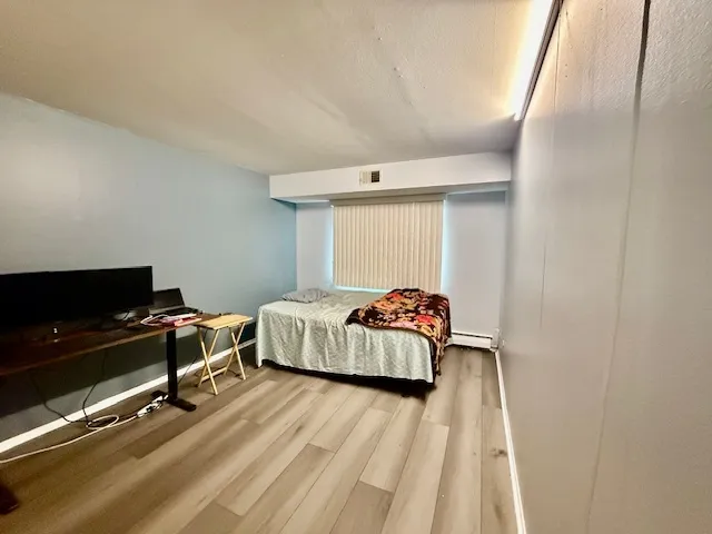 a bedroom with a bed and a flat tv screen on the dresser