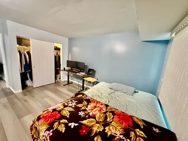 a bedroom with a bed and a lamp on dresser