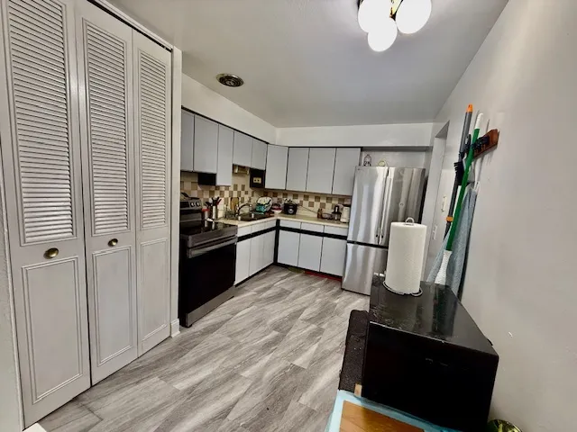 a kitchen with stainless steel appliances granite countertop a refrigerator and a sink