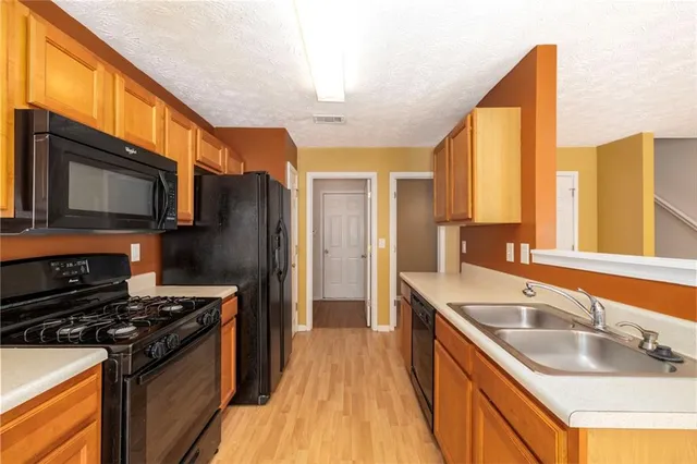 a kitchen that has a sink and a stove top oven