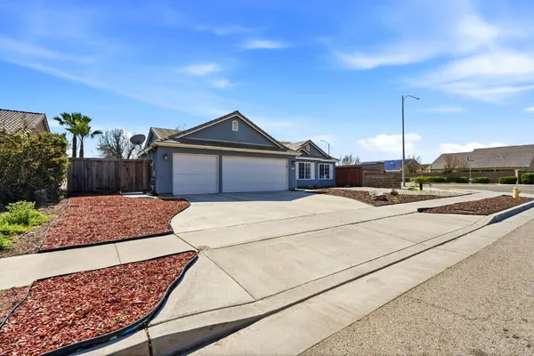 a view of a house with a yard and potted plants