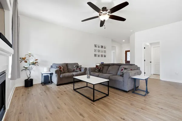a living room with furniture a flat screen tv and a fireplace