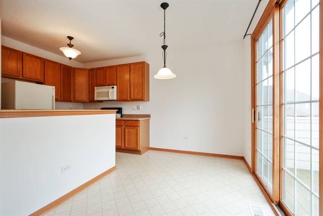 15652 Scotsglen Road Orland Park, IL 60462 - Photo 5 of 15 a kitchen with kitchen island a counter top space a sink stainless steel appliances and cabinets