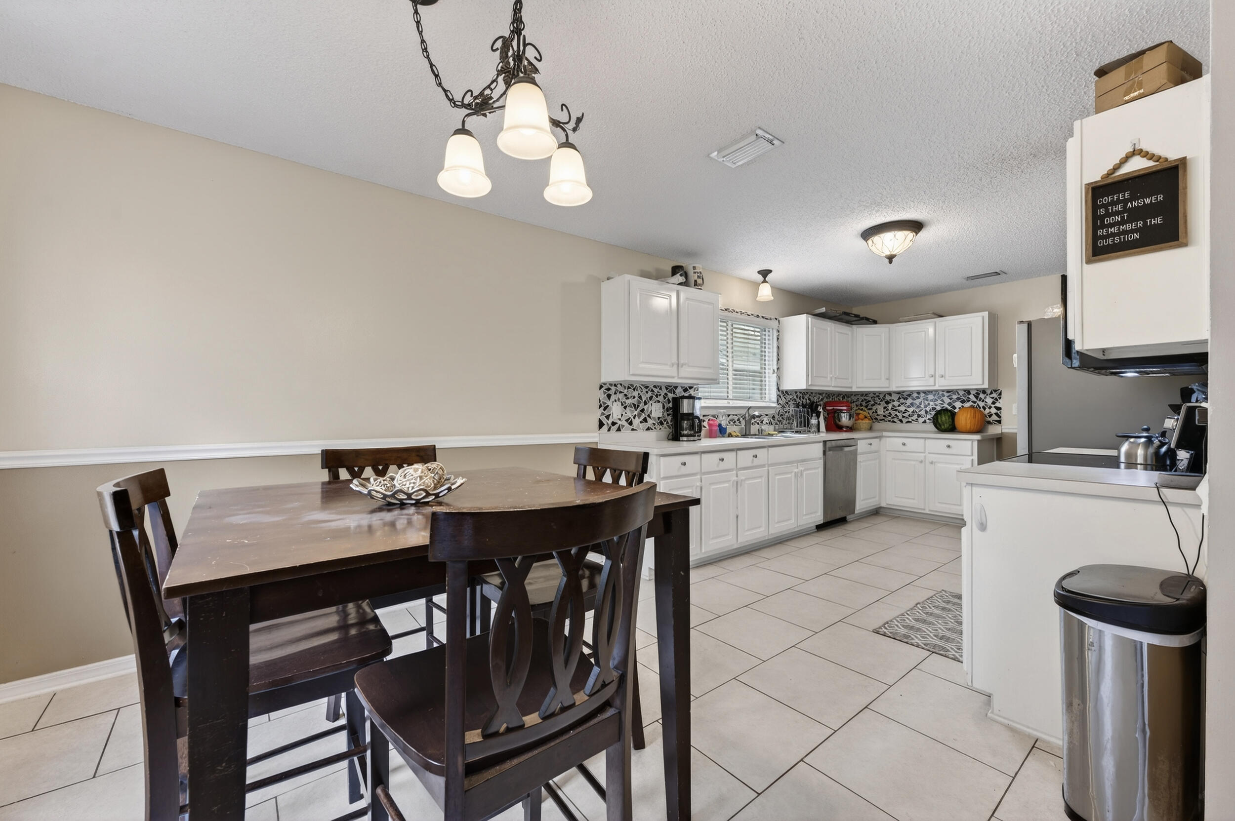 4717 Whitewater Lane Crestview, FL 32539 - Photo 13 of 55 a kitchen with a dining table chairs and refrigerator