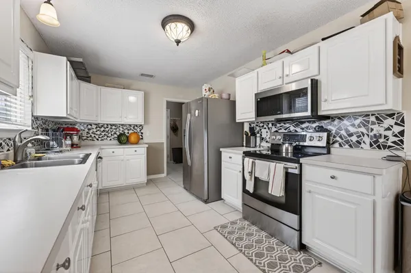 a kitchen with stainless steel appliances a refrigerator sink stove microwave and cabinets