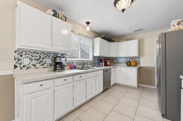 a kitchen with white cabinets and white appliances
