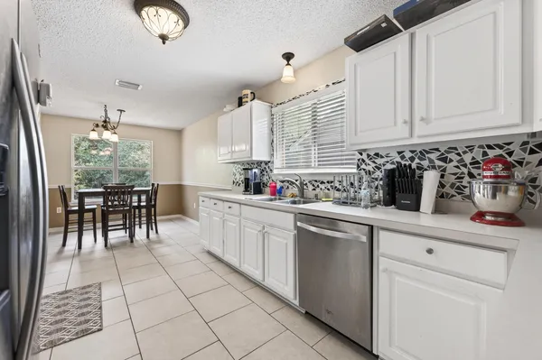 a kitchen with stainless steel appliances a sink window and cabinets