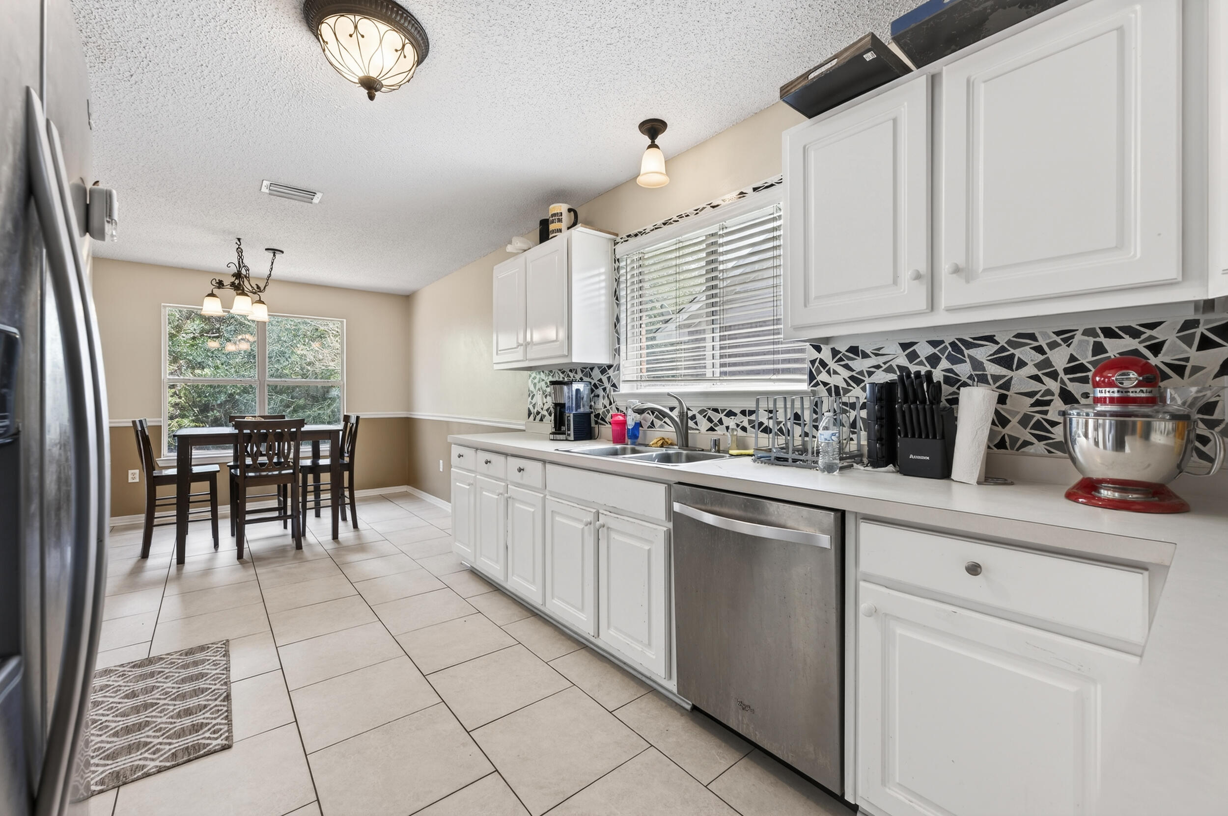 4717 Whitewater Lane Crestview, FL 32539 - Photo 18 of 55 a kitchen with stainless steel appliances a sink window and cabinets