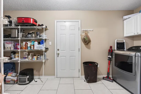 a view of a kitchen with fridge and workspace