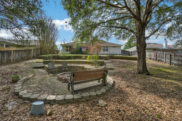 a view of a small yard in front of a house with wooden fence