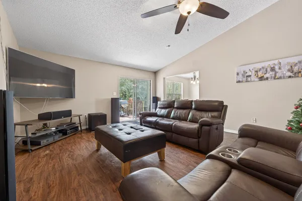 a living room with furniture a ceiling fan and a wooden floor