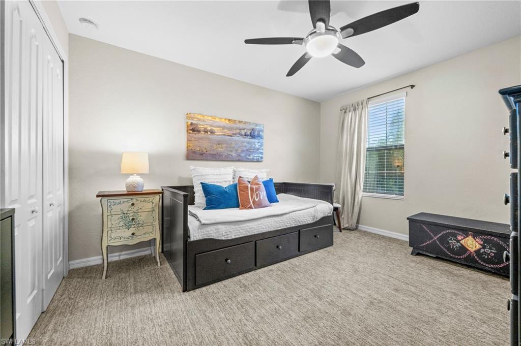 4754 Abaca Circle Naples, FL 34119 - Photo 23 of 46 a room with a bed and a chandelier