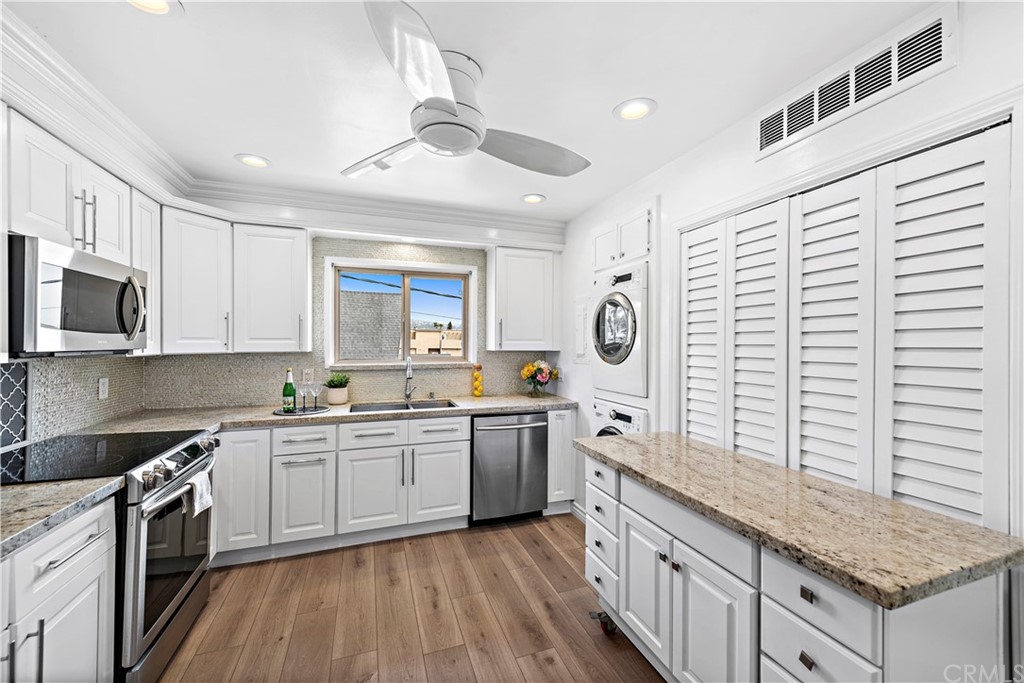 520 Cliff Drive, Unit 303 Laguna Beach, CA 92651 - Photo 13 of 46 a kitchen with stainless steel appliances granite countertop wooden cabinets a sink a stove a refrigerator and island