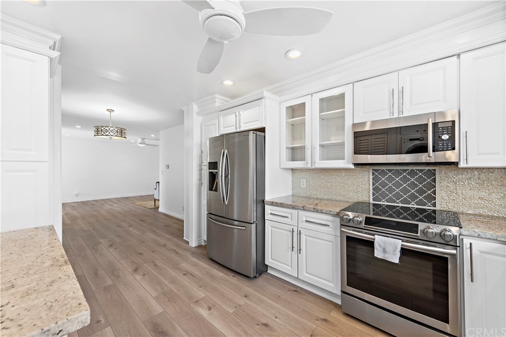 520 Cliff Drive, Unit 303 Laguna Beach, CA 92651 - Photo 15 of 46 a kitchen with stainless steel appliances and wooden floor