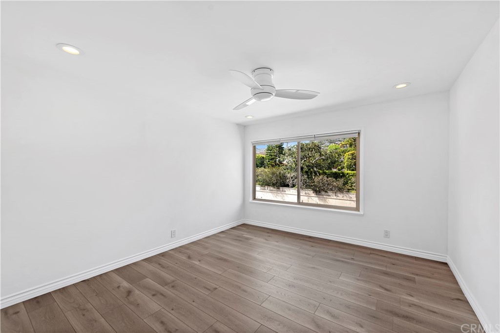 520 Cliff Drive, Unit 303 Laguna Beach, CA 92651 - Photo 24 of 46 an empty room with wooden floor and windows