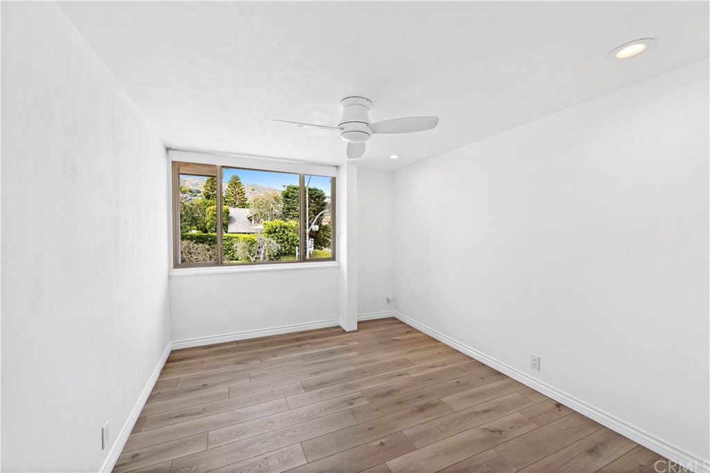 520 Cliff Drive, Unit 303 Laguna Beach, CA 92651 - Photo 8 of 46 an empty room with wooden floor fan and windows