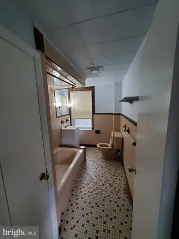 a bathroom with a tub sink and mirror